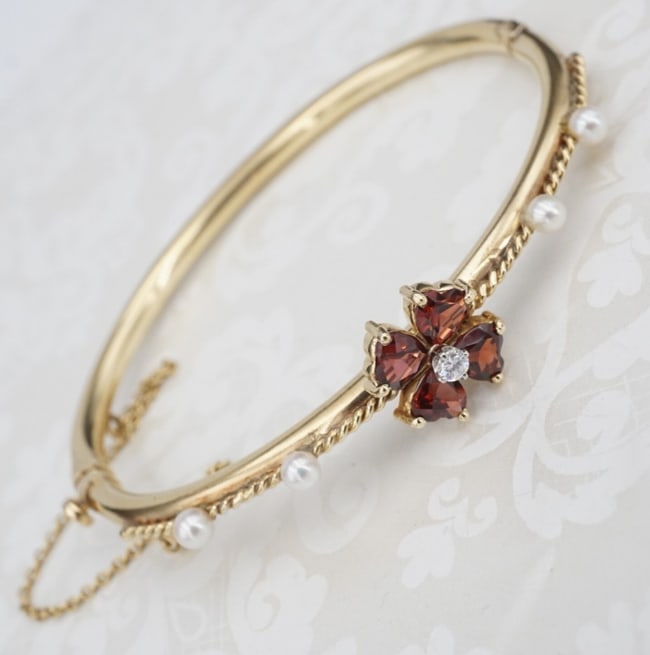 Vintage Diamond Garnet Pearl Hinged Bangle Bracelet 14k Yellow Gold 6.5" BG969: This gorgeous hinged bangle is set with a flower of heart-shaped garnets with a diamond accenting the center. Darling seed pearls and rope accents run the length of the face. The bracelet hinges open 