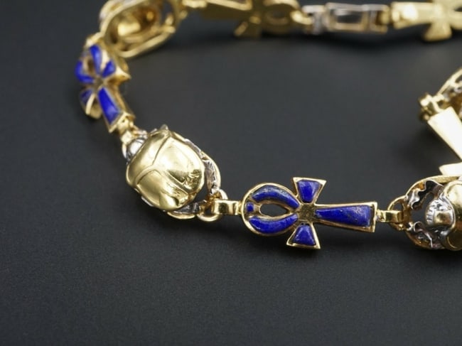 Vintage 2-Tone 18k Gold Lapis Lazuli Inlay Scarab Ankh Bracelet 7.75" 8mm BG511: This vintage bracelet is crafted of alternating links featuring Egyptian scarab and ankh symbols. The scarabs are crafted of white and yellow gold. The ankh features beautiful lapis lazuli inlay. A un