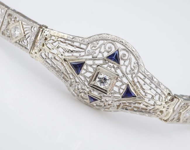 Art Deco 14k Sapphire Diamond Panel Bracelet Gold Antique 7" Filigree BG1098: This vintage Art Deco bracelet features an ornate, filigree panel design embellished with a natural round diamond at center framed by vivid blue sapphire trillions. The shoulders are embellished with 