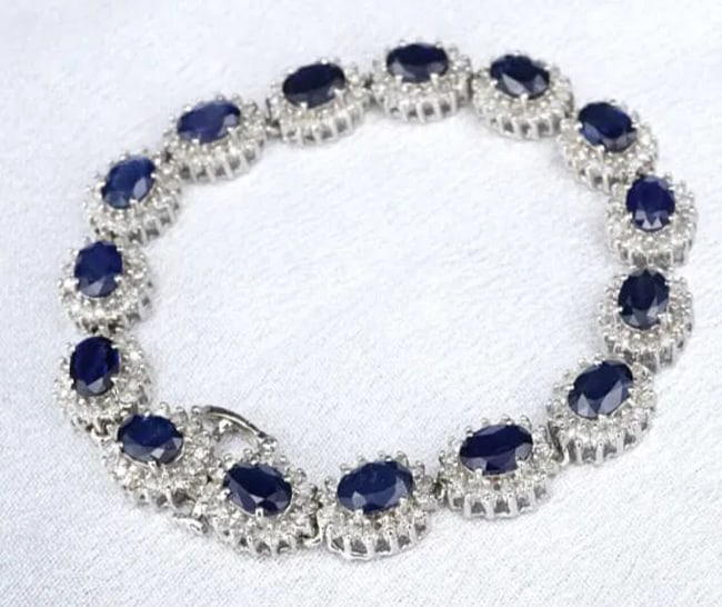 14k White Gold 16cttw Natural Sapphire Diamond Halo Tennis Bracelet 7.25" BG879: This sapphire and diamond bracelet features oval cut sapphire stations set with natural diamond halos, all crafted of solid 14k white gold. The bracelet fastens with a hidden insert clasp for a seamle