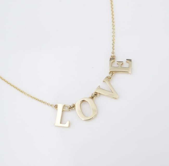 Yellow Gold LOVE Pendant Necklace 18" Articulated 9k NG1730: This adorable necklace features the word "Love" in a all caps, each letter articulated to the next for a comfortable fit. The pendant is suspended gracefully from a solid 9k yellow gold cable chain wi