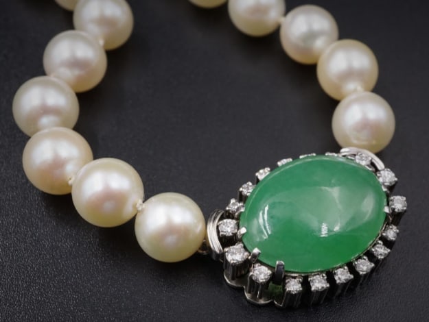 14k White Gold Green Jade Diamond Halo Pearl Convertible Necklace 32" 8mm CO327: This beautiful vintage necklace features a long single strand of lustrous pearls that culminate in a translucent green jade cabochon clasp, set in white gold and surrounded by diamond halo. The ornate