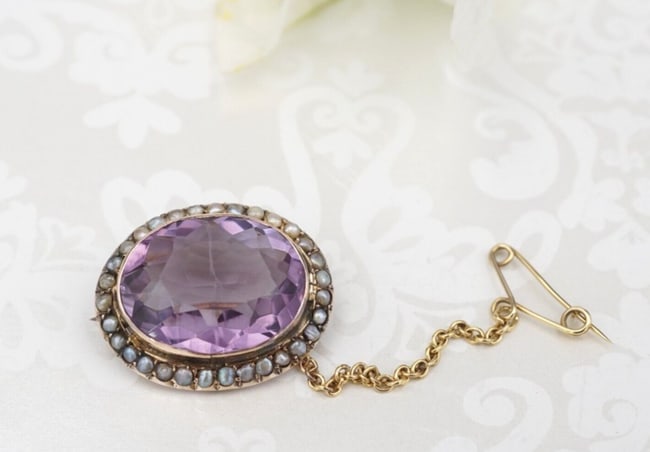 Antique 9k Gold Amethyst Seed Pearl Pin Brooch 1" Natural OG531: This beautiful antique pin features a vivid purple oval amethyst bezel set in a luxe gold frame with a stunning seed pearl halo. A safety chain attached to a secondary pin allows for extra security wh