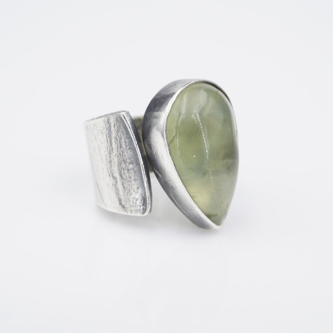Sterling Silver Cocktail Ring Bypass Adjustable Size 7 Artisan Prehnite: This beautiful ring features a large, pear shaped prehnite cabochon bezel set atop a chunky, adjustable sterling silver band. A gorgeous statement piece for any jewelry collection! Metal Type: Sterlin