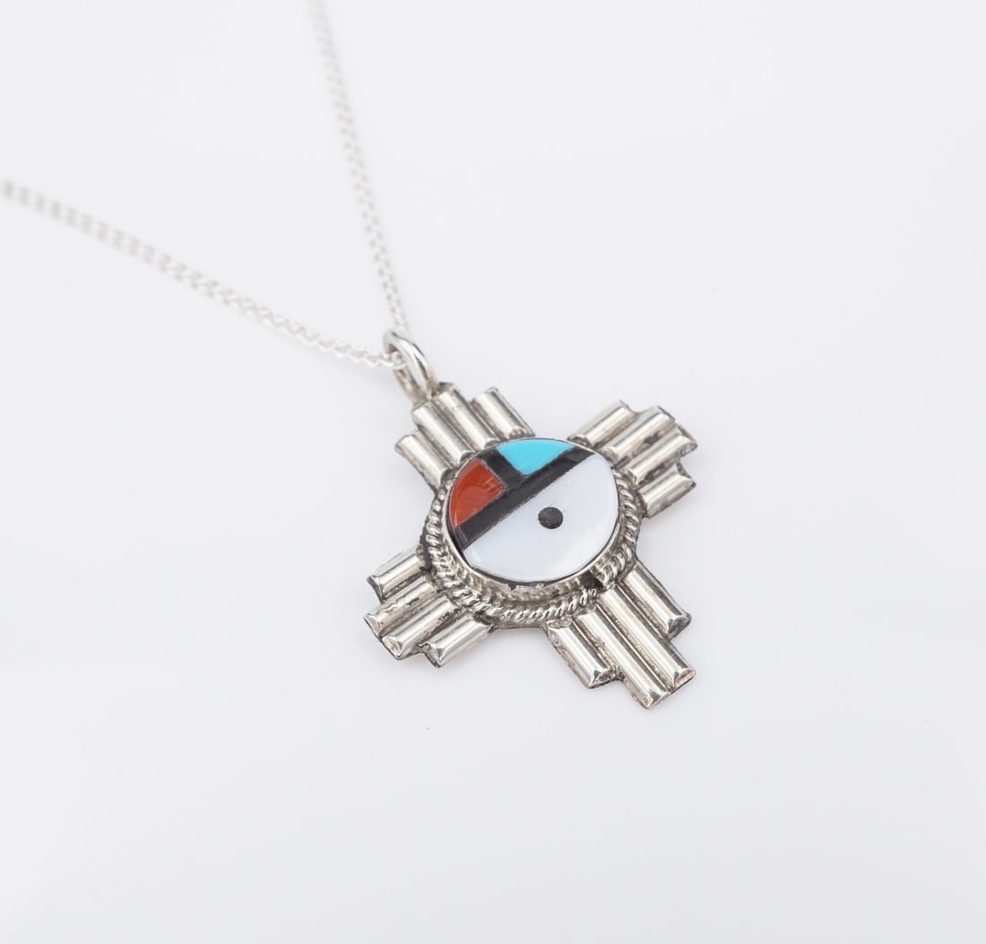 Zuni Sterling Silver Sun Face Multi-Gemstone Necklace 20" Clifford Cheama: This gorgeous necklace from Zuni artisan Clifford Chema features a classic sterling silver Zia sun symbol design crafted of inlaid turquoise, mother of pearl, red coral and jet. Suspended from a wheat