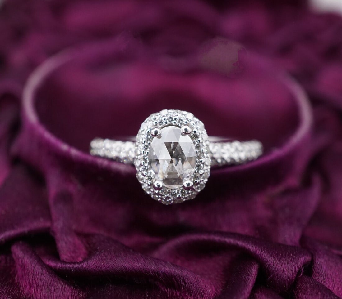 18k White Gold 1.4 ctw Oval Rose Cut Diamond Halo Engagement Ring Size 6: This gorgeous ring features a rose-cut oval natural diamond surrounded by a diamond halo with additional diamonds cascading down the shoulders of the polished white gold band. Perfect as a stunning en