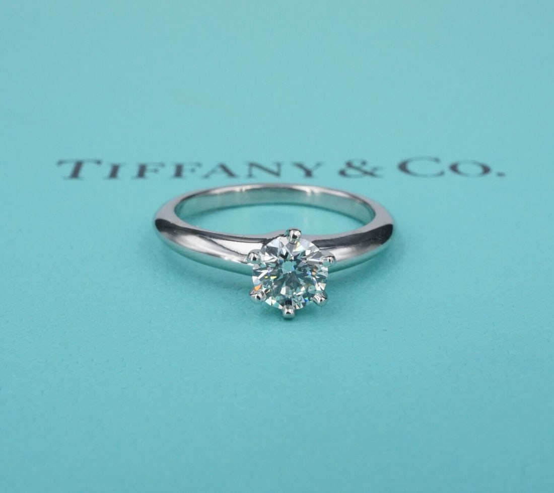 Tiffany & Co Diamond Engagement Ring Platinum .62ct H VS1 Size 5.5: This beautiful Tiffany & Co ring is a classic design, featuring a central round cut diamond set in platinum. The 6-prong setting and polished platinum allows the diamond to shine bright and white! A g
