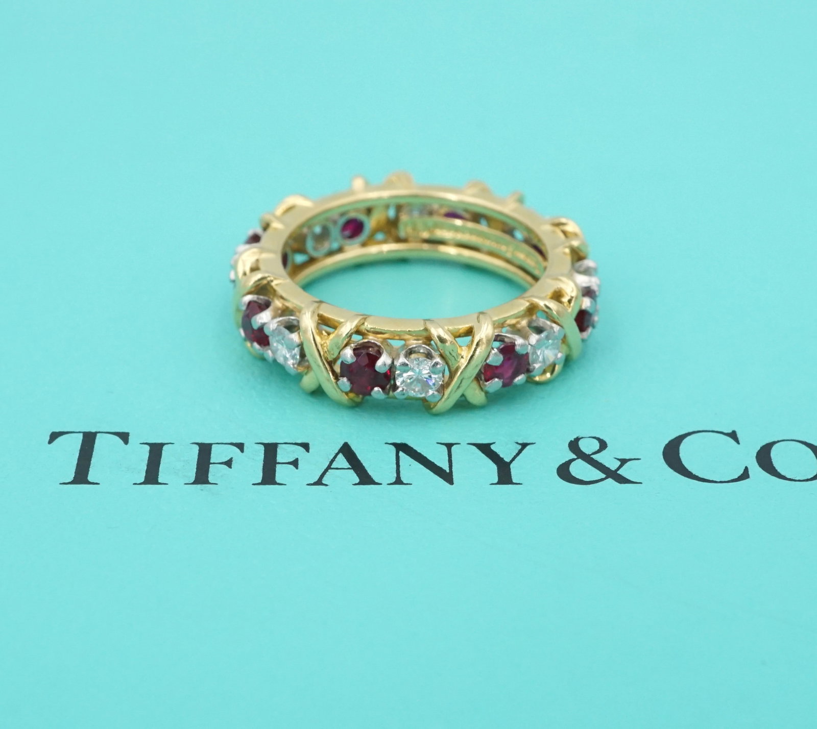 Tiffany Schlumberger 16 Stone 18k Gold Diamond Ruby Band X Ring Sz 6: This lovely Tiffany & Co. ring by Jean Schlumberger features 16 gorgeous red rubies and sparkling diamonds with X accents alternating across the entirety of the luxe 18k yellow gold and platinum band.