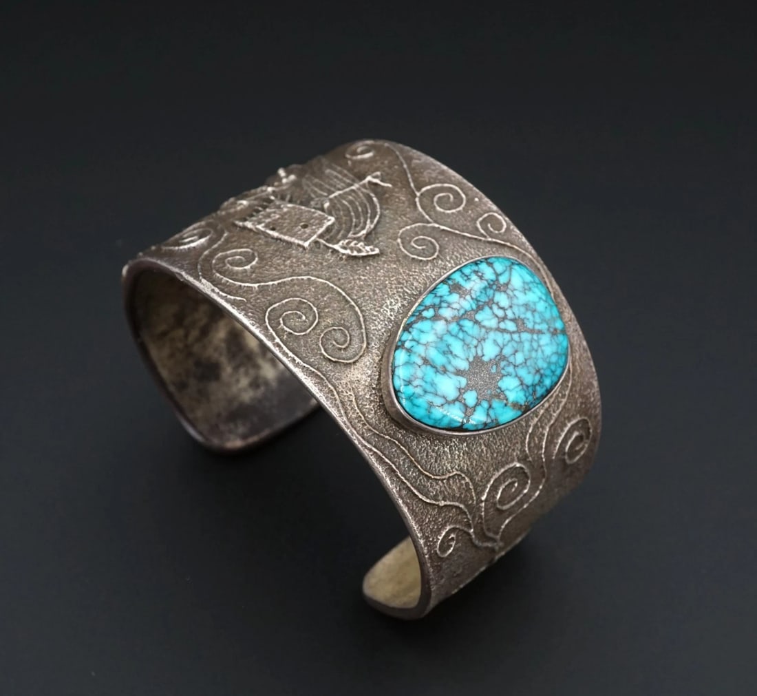 Philander Begay Tufa Cuff Bracelet Sterling Silver Turquoise 6.5" Navajo BS982: This stunning bracelet from Navajo designer Philander Begay features a chunky, tufa cast cuff bracelet embellished with a large, bezel-set gem turquoise cabochon and intricate carved designs of a kach