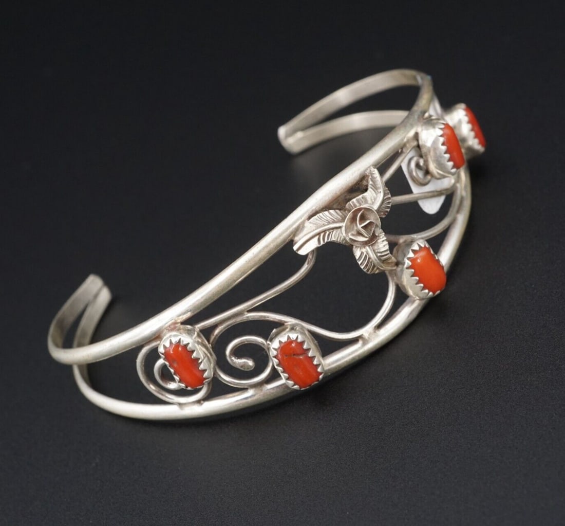 Navajo Sterling Silver Coral Cuff Bracelet Open Swirl Carolyn Nez 6.75" BS2806: This lovely cuff bracelet features an opal swirl design with a flower and coral accents. The split shoulders provides an added visual touch. A simple statement piece and a great addition for any colle