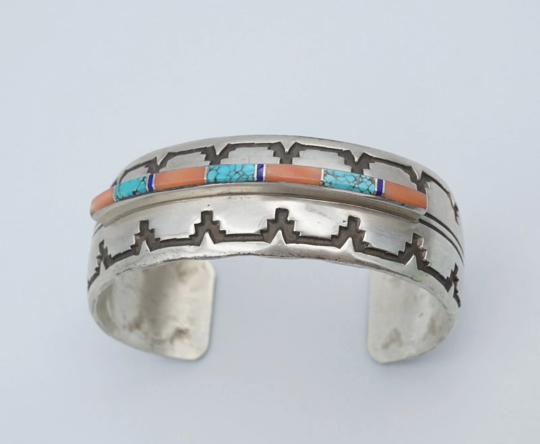 Navajo Inlay Cuff Bracelet Sterling Silver Turquoise Onyx 6.5" Signed WM BS3170: This unique Native American artisan cuff features a raised inlay of turquoise, coral and onyx set atop a wide sterling silver cuff bracelet. Complete with hand stamped details, this gorgeous cuff is g