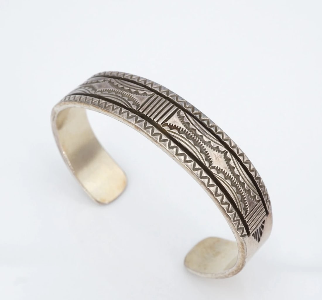 Vtg Navajo Sterling Silver Cuff Bracelet Hand Stamped 6.5" Bruce Morgan BS3208: This chunky bracelet from Navajo artisan Bruce Morgan is crafted of solid sterling silver and features intricate hand stamped detailing throughout. Sleek and simple, this piece is great worn on its ow