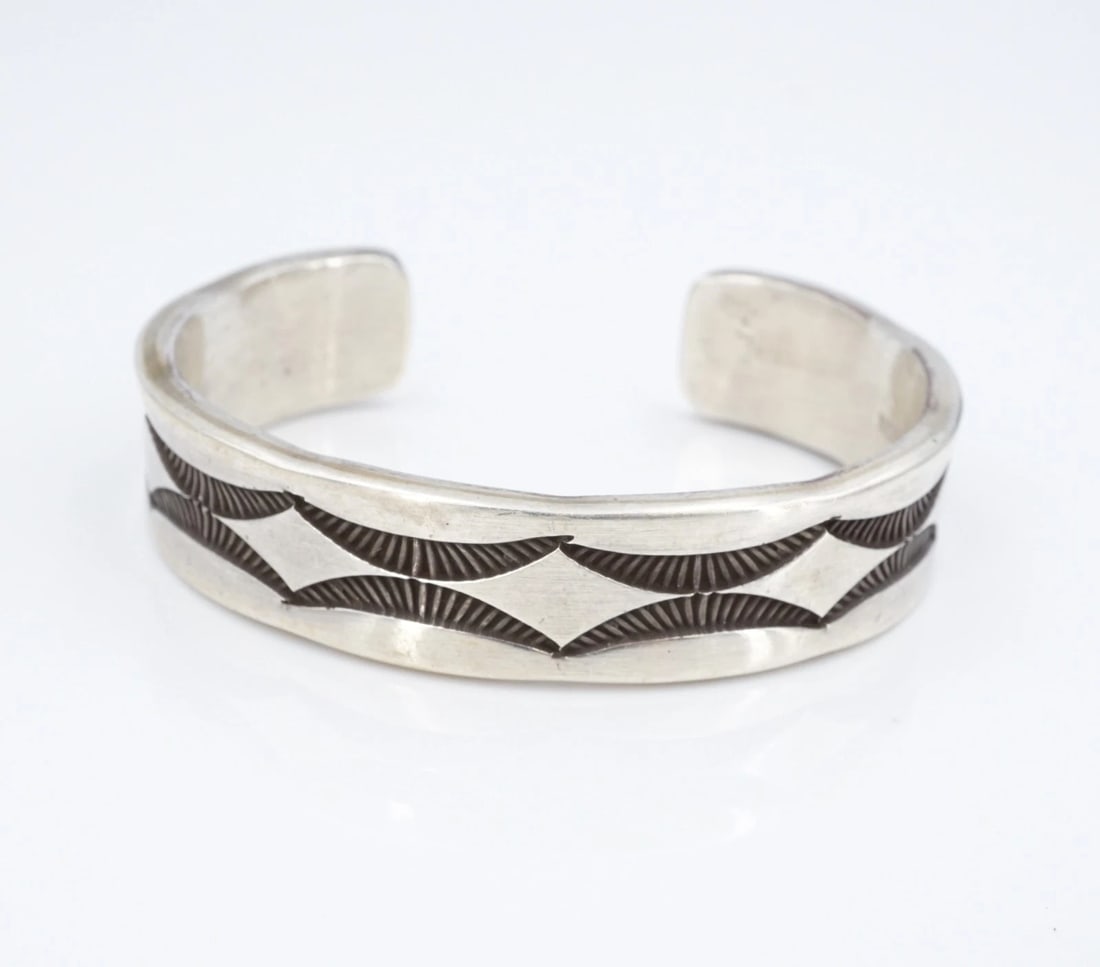 Navajo Sterling Silver Cuff Bracelet Hand Stamped 6.75" Nora Tahe Bill BS3183: This beautiful bracelet from Navajo artisan Nora Tahe Bill features a wide sterling silver cuff embellished with intricate hand stamped designs across the face. Sleek and simple, this piece is great w