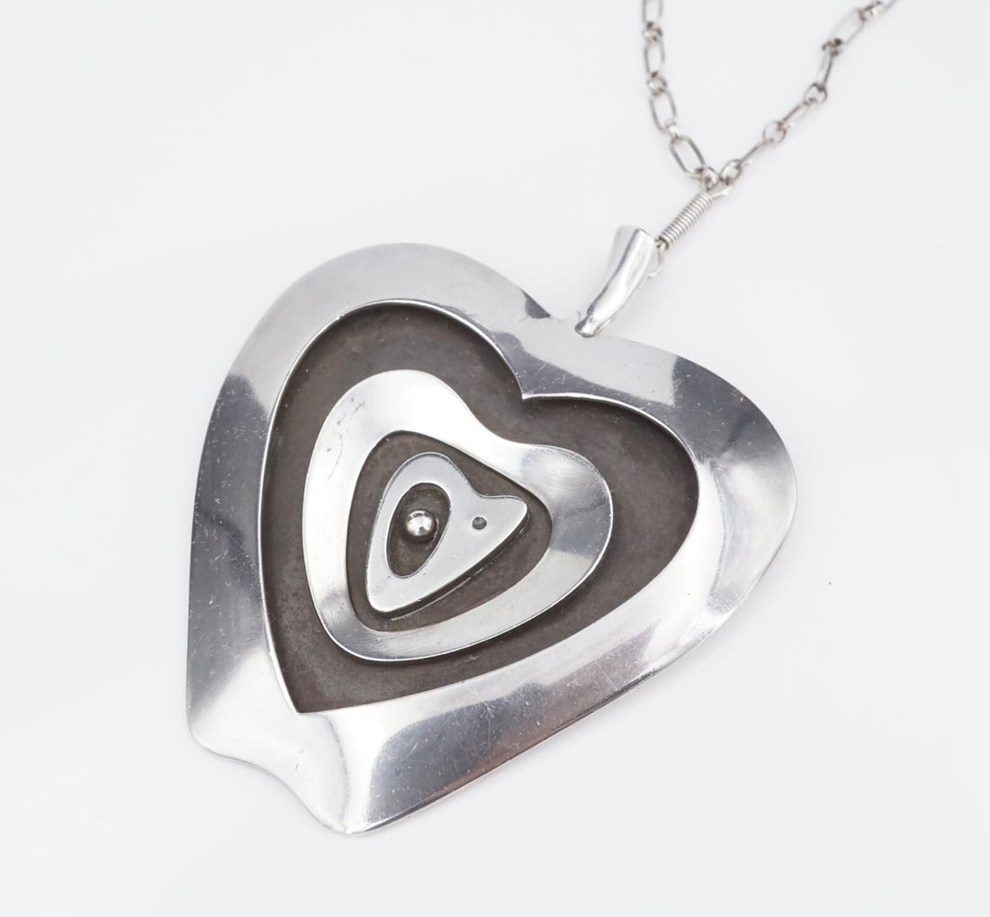 Navajo Norbert Peshlakai Sterling Silver Abstract Pendant Necklace 24" NS2286: This Navajo pendant necklace by artist Norbert Peshlakai features unique apple shaped pendant layered with abstract shapes. Suspended from a hand crafted chain, this piece is perfect for any collector