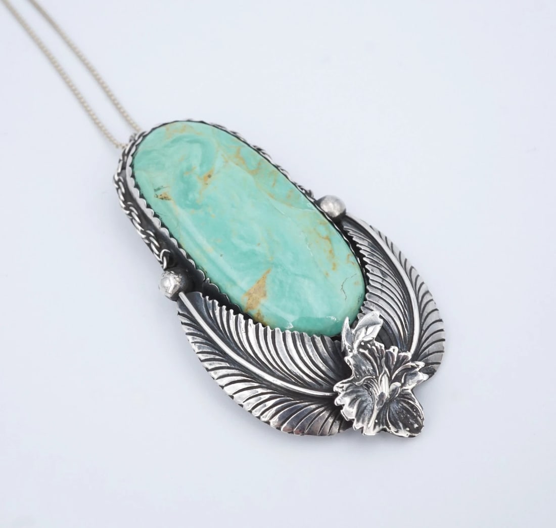 Native American Turquoise Pendant Leaf Sterling Silver 2.7" Signed PS2326: This stunning sterling silver pendant from features a large, oval turquoise cabochon bezel set in a chunky sterling silver frame embellished with large feather motifs at the base. Complete with rope d