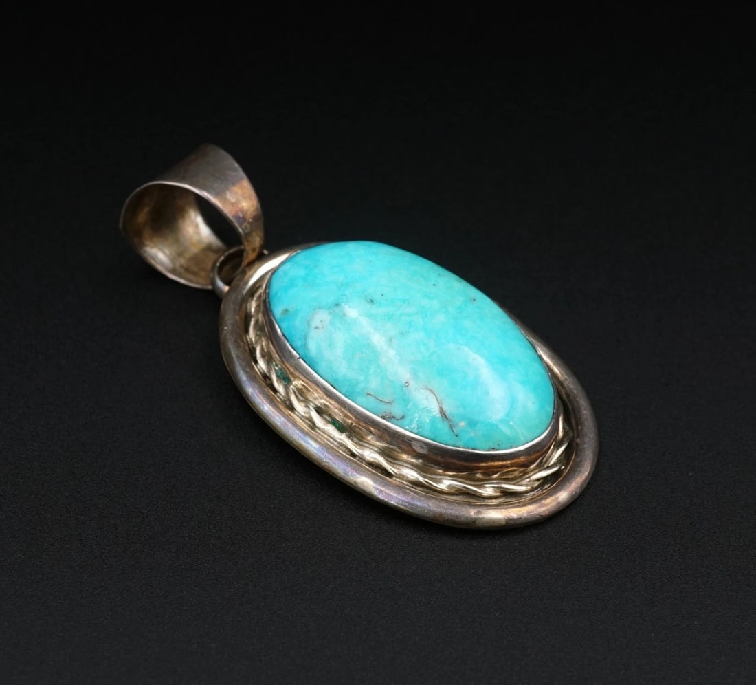 Navajo Chimney Butte Turquoise Pendant Sterling Silver 2.1" Natural PS2375: This chunky pendant from Navajo artisan Chimney Butte features a large blue turquoise cabochon bezel set atop a large ovular pendant with a ornate rope designs. All crafted of solid sterling silver, t