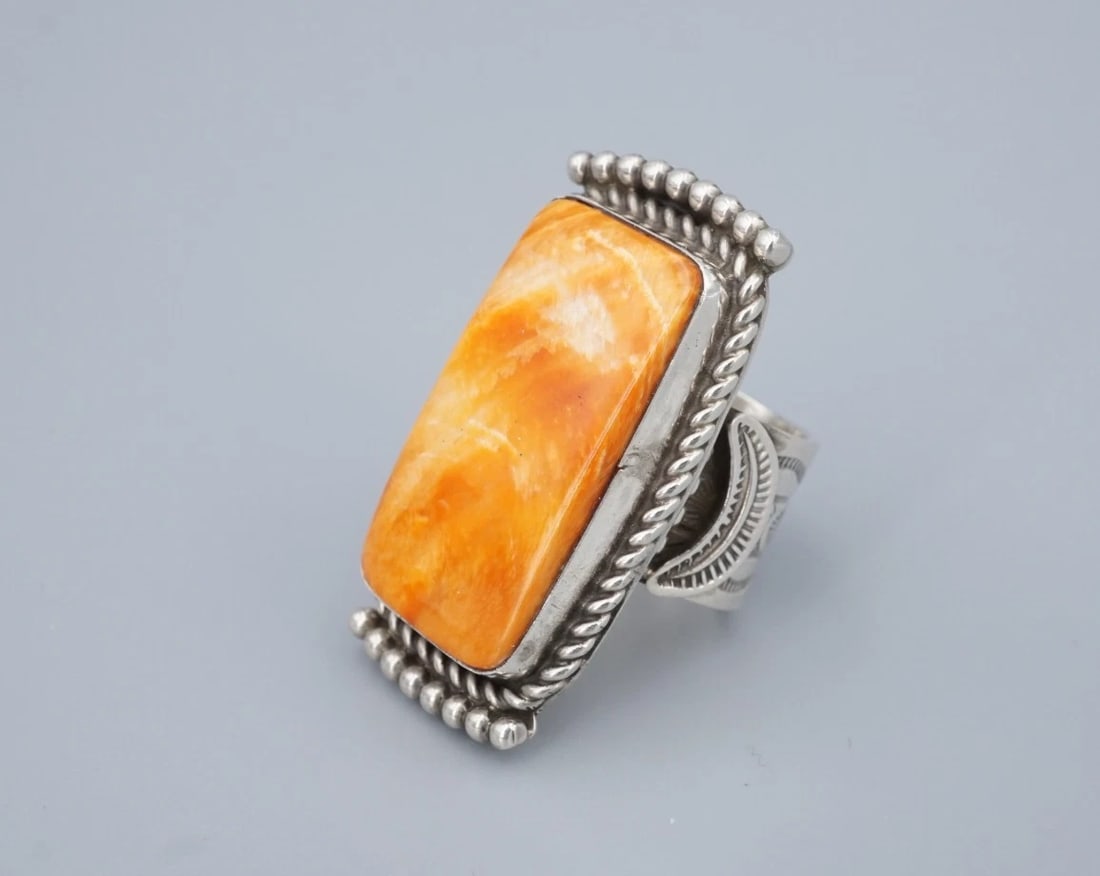 Navajo Spiny Oyster Statement Ring Sterling Silver Alex Sanchez Size 9 RS3838: This beautiful ring from Navajo artisan Alex Sanchez centers on a rectangular, orange spiny oyster cabochon bezel set atop a chunky sterling silver mount. The entire ring is embellished with rope desi