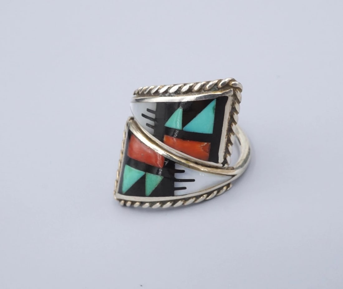 Zuni Multi-Stone Inlay Band Ring Sterling Silver Size 7 Charles M. Booqua RS3785: This beautiful ring from Zuni artisan Charles M. Booqua a geometric inlay of turquoise, red coral, mother of pearl, and onyx set flush in a solid sterling silver band with a bypass design. This ring i