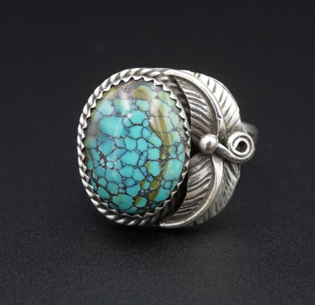 Navajo Sterling Silver Spiderweb Turquoise Ring Vintage Size 8.25 Artisan RS3433: This rustic artisan vintage ring features a deep blue-green oval cabochon of spiderweb turquoise set in a serrated bezel with a rope border and feather detailing. All hand crafted of sterling silver. 