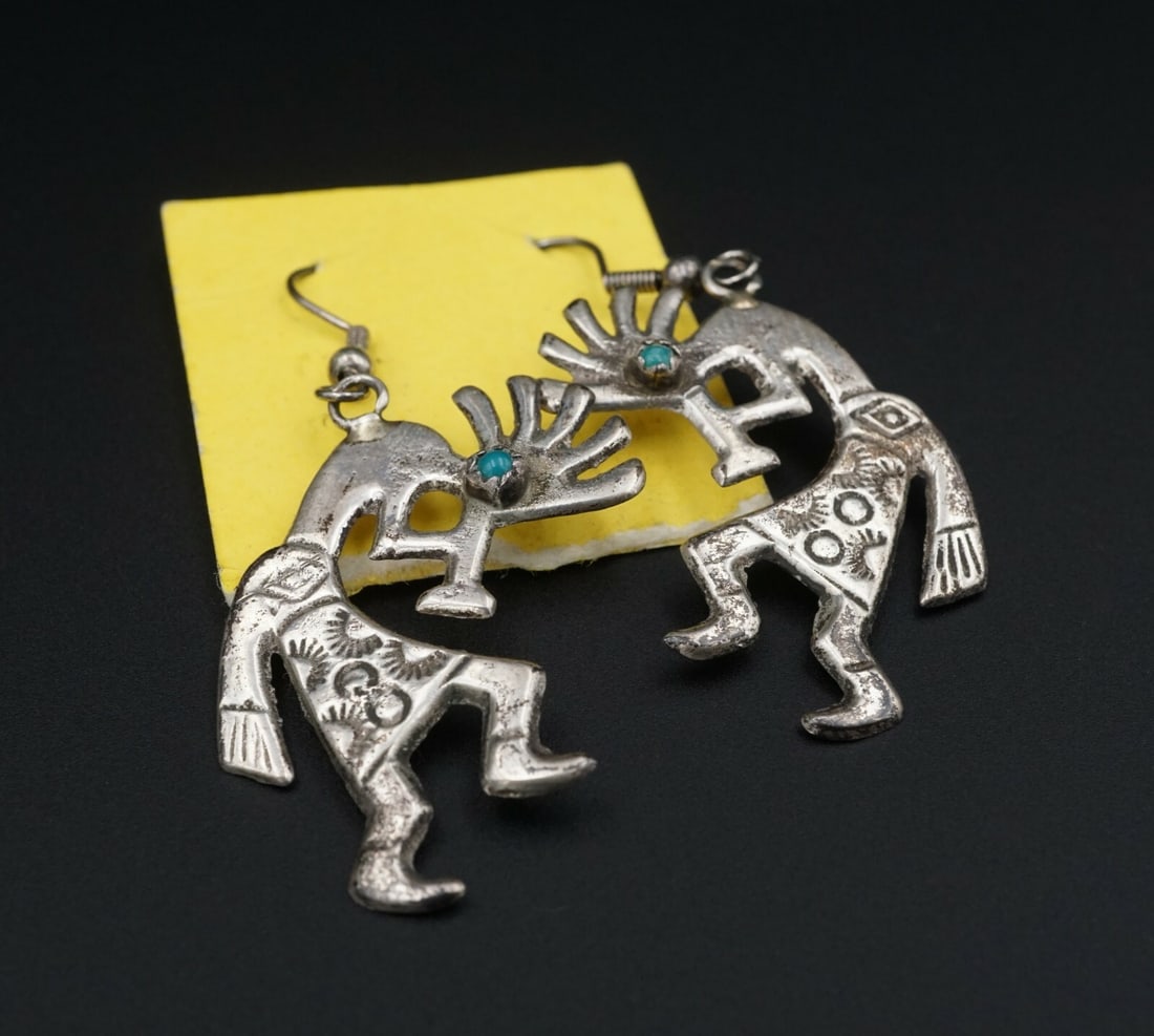 Fred Harvey Sandcast Sterling Kokopelli Turquoise Earrings ES2180: This beautiful pair of Fred Harvey Trading Company sandcast dangle earrings depict the traditional kokopelli humpbacked flute player with turquoise eyes and hand stamped details. Dangling from wire ho