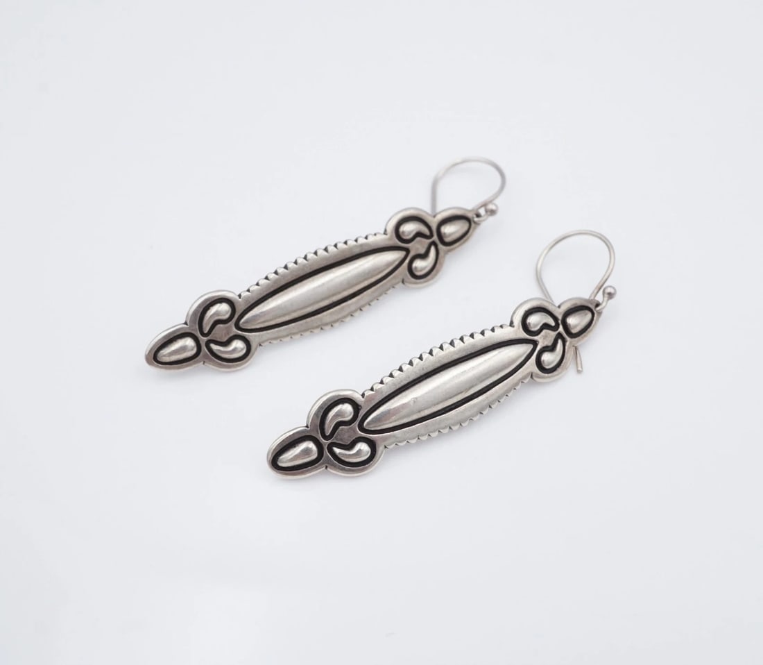 Cody Sanderson Drop Earrings Sterling Silver Stamped Santa Fe 2.5" Relios ES2818: These gorgeous earrings by Navajo/Dine artisan Cody Sanderson for Relios feature an elongated sterling silver bar design with a serrated border and raised dome accents on each tip. Complete with a stu
