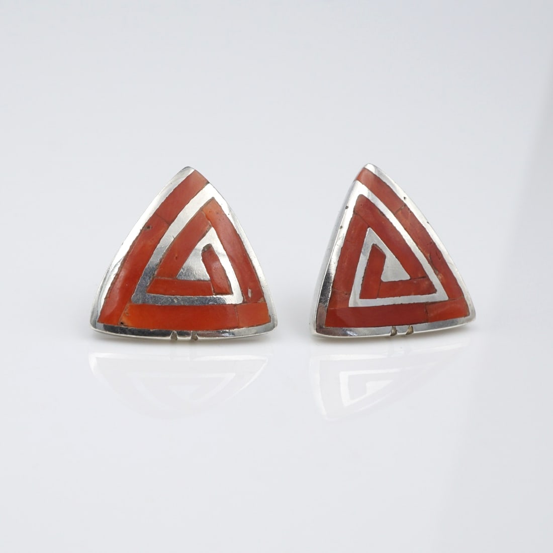 Southwestern Coral Inlay Triangle Earrings Sterling Silver Geometric 3/4" ES2724: These Southwestern earrings feature a triangular stud set in solid sterling silver with an ornate spiral design crafted of vibrant coral or spiny oyster. A fun accessory for day or night! Metal Type: 