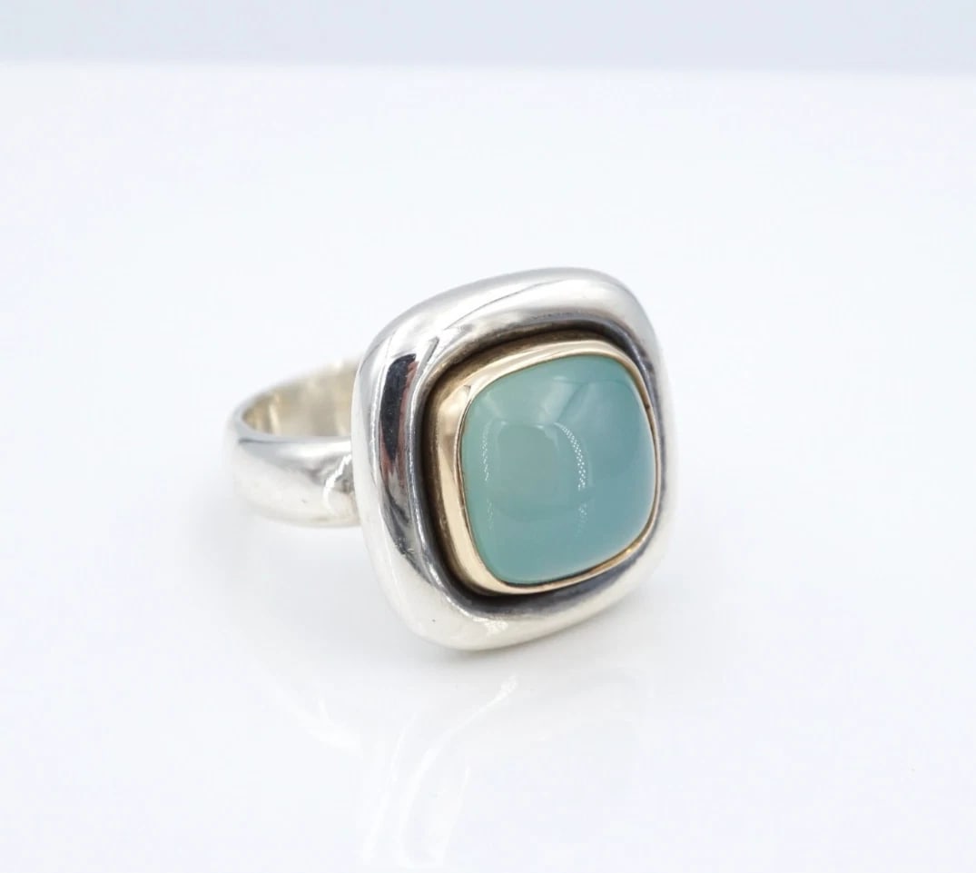 James Avery Rosetta Chalcedony Ring Sterling 14k Gold 7.75" HTF Retired RS4028: This rare and retired James Avery "Rosetta" ring features a large chalcedony cabochon set in a solid 14k yellow gold bezel atop chunky sterling silver mount. Metal Type: Sterling Silver Notable Marks: