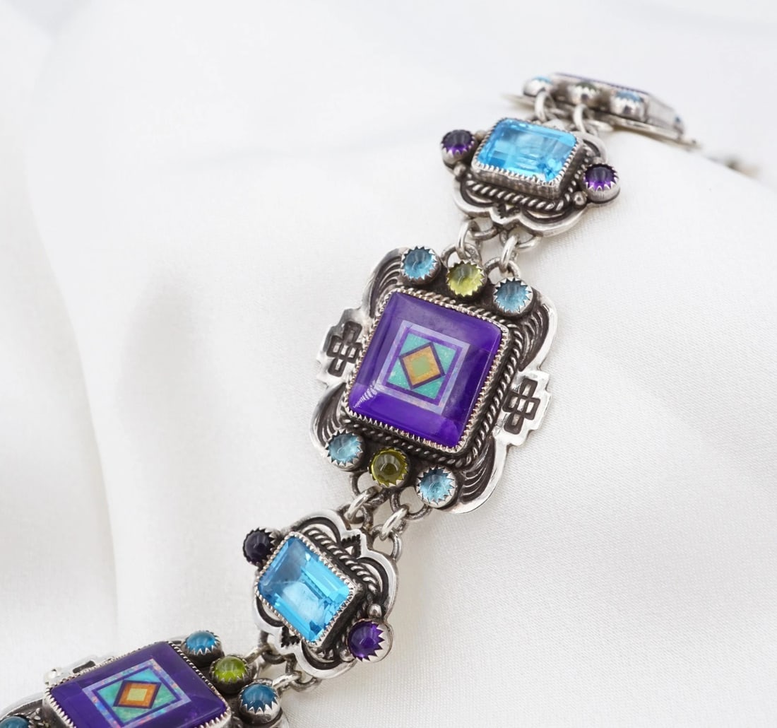 Benny & Valerie Aldrich Art Sterling Silver Inlay Panel Bracelet Topaz 7" BS3275: This bracelet from the Aldrich Art features a geometric inlays of turquoise, sugilite and opal with gem set stations on this articulated sterling silver bracelet. Complete with a sturdy insert clasp a