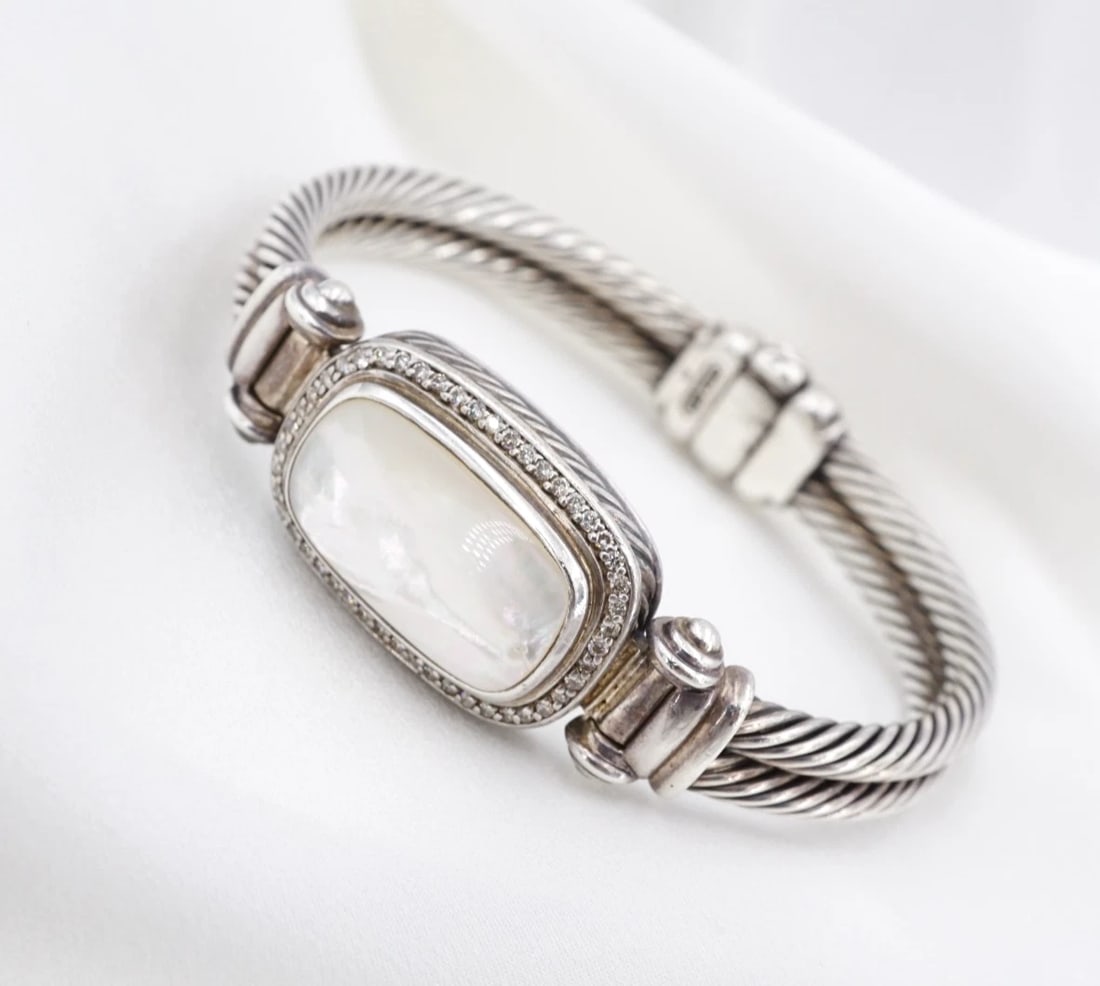 David Yurman Double Cable Bracelet MOP Diamond Sterling Silver 6.5" BS3363: This hinged bracelet from David Yurman features an elongated mother of pearl slab framed by a natural diamond halo and bezel-set in a sterling silver construction with an intricate double cable design