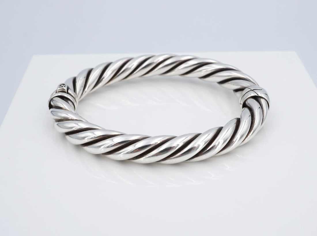 David Yurman Sculpted Cable Hinged Bangle Bracelet Sterling 10mm 6.5" BS3322: This retired bracelet from David Yurman features the iconic cable classic cuff design crafted in a chunky sterling silver bangle with a locking hinged closure. Metal Type: Sterling Silver Notable Mark