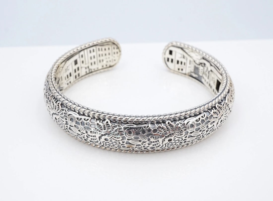 JAI Captured Moment Venice Cuff Bracelet Sterling Silver 8" John Hardy BS3330: This classic bracelet from JAI's Out of Italy collection, features a solid sterling silver kick-cuff embellished with a continuous floral repousse design on the face, and an ornate waterfront cityscap