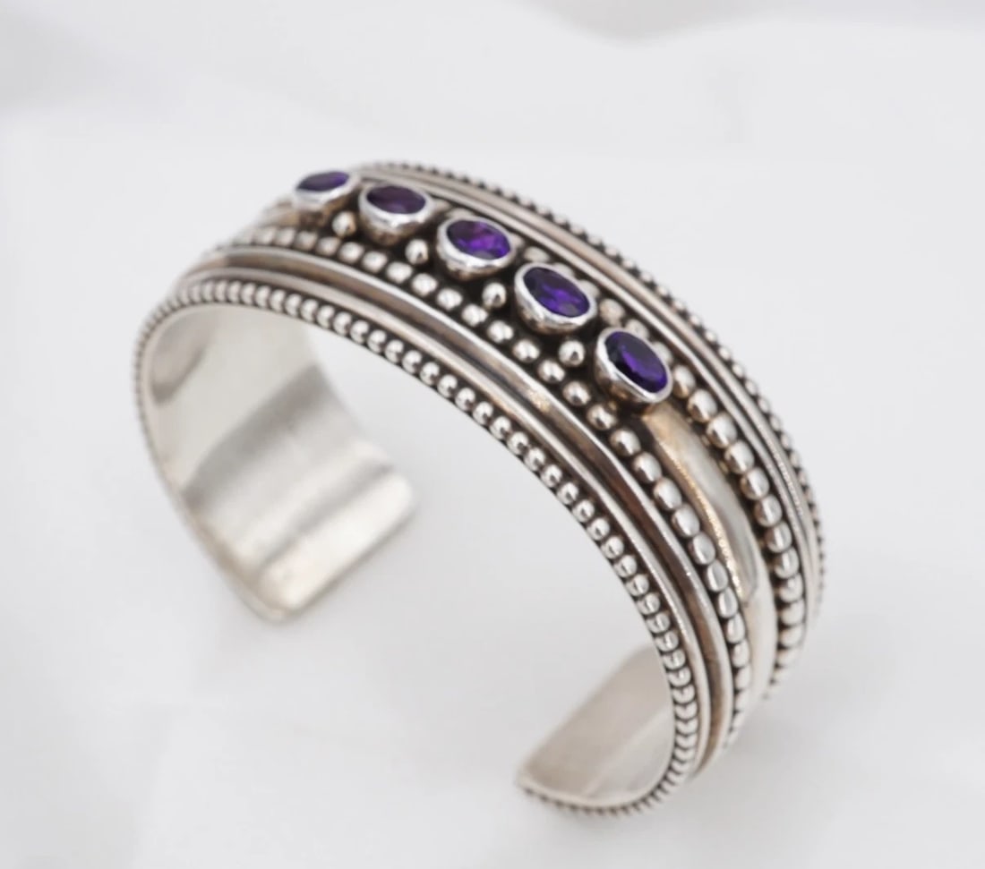 Juan Willie Amethyst Cuff Bracelet Sterling Silver 6.25" 20.7mm Navajo BS3367: This bracelet from Navajo designer Juan Willie features a wide sterling silver cuff design embellished with a row of five natural, oval-cut amethyst gemstones bezel-set across the face. Metal Type: St