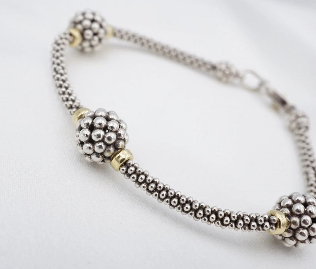 Lagos Caviar Ball Station Bead Bracelet Sterling Silver 18k 7.5" BS3352: This Lagos Caviar bracelet features 3 ball stations on a sterling silver beaded bracelet with 18k spacer beads. Metal Type: Sterling Silver & 18k Yellow Gold Notable Marks: Lagos Measurements: 7.5"; 1