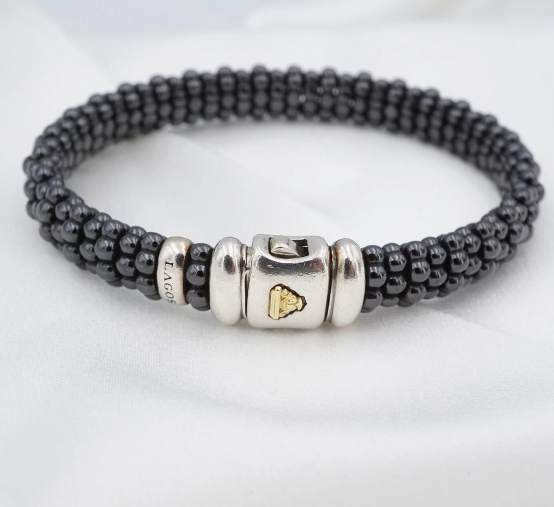 Lagos Caviar Black Ceramic Bead Bracelet Sterling Silver 18k 6.5" BS3354: This elegant Lagos Caviar bracelet is crafted in sterling silver with glossy black ceramic beads and a signature 18k yellow gold accent. The flexible bangle design is finished with a secure box clasp,