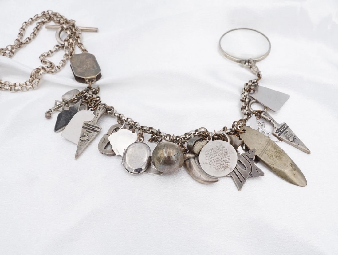 Eclectic Charm Pendant Necklace Sterling Silver Designer David Navarro NS2457: This necklace from Artist David Navarro features a thick cable chain with a y-style pendant loaded with an eclectic collection of charms. Crafted in solid sterling silver. Metal Type: Sterling Silver 