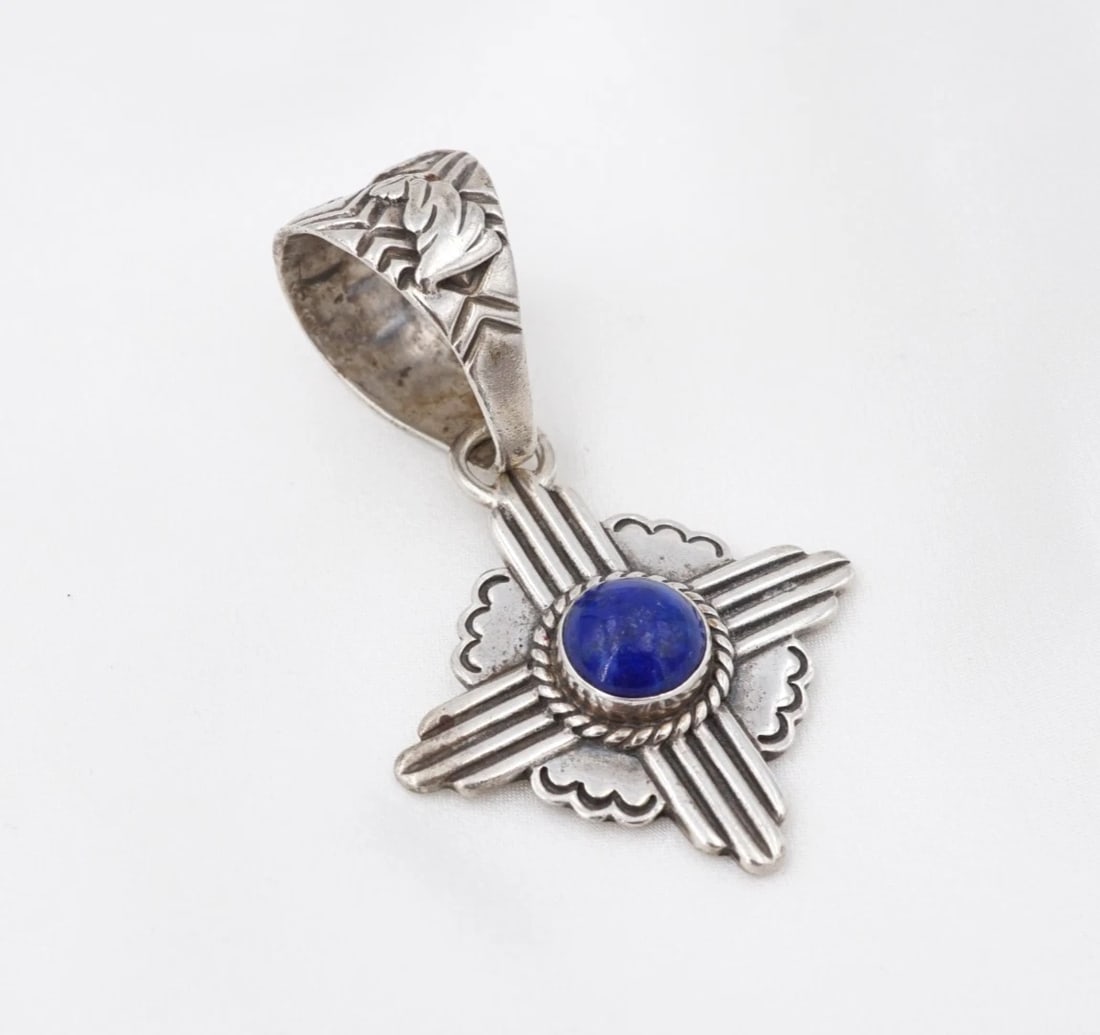 Murray Jackson Lapis Zia Sun Pendant Sterling Silver Stamped 2" Walapai PS2386: This pendant from Walapai artisan Murray Jackson centers on a large lapis cabochon bezel set atop an ornate Zia sun symbol crafted in solid sterling silver. Complete with a large bale adorned with han