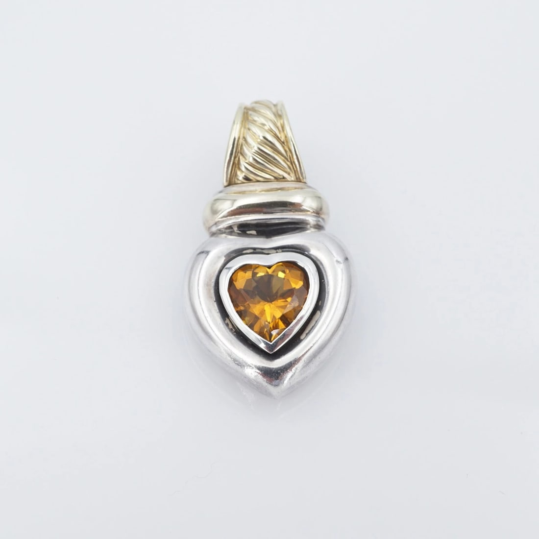 David Yurman Citrine Heart Cable Pendant Enhancer Sterling 14k 1.25" PS2319: This enhancer pendant from David Yurman features a vivid, heart shaped citrine gemstone bezel set in a solid sterling silver frame complete with a large 14k yellow gold enhancer bale with an ornate ca