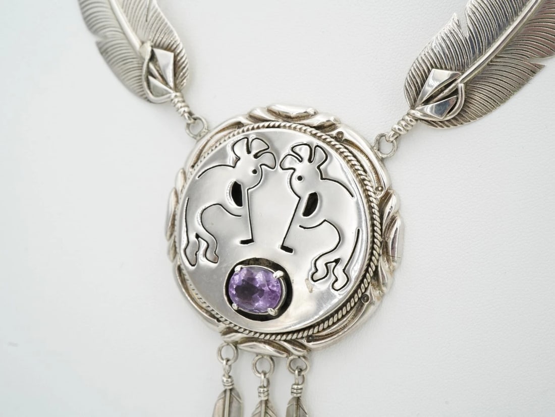 Kokopelli Navajo Necklace Jeff James Jr. Amethyst Sterling Silver 22" NS2493: This statement necklace from Navajo artisan Jeff James Jr. centers on a large circular pendant embellished with a natural oval-cut amethyst and stamped with a double Kokopelli motif. Three detailed fe
