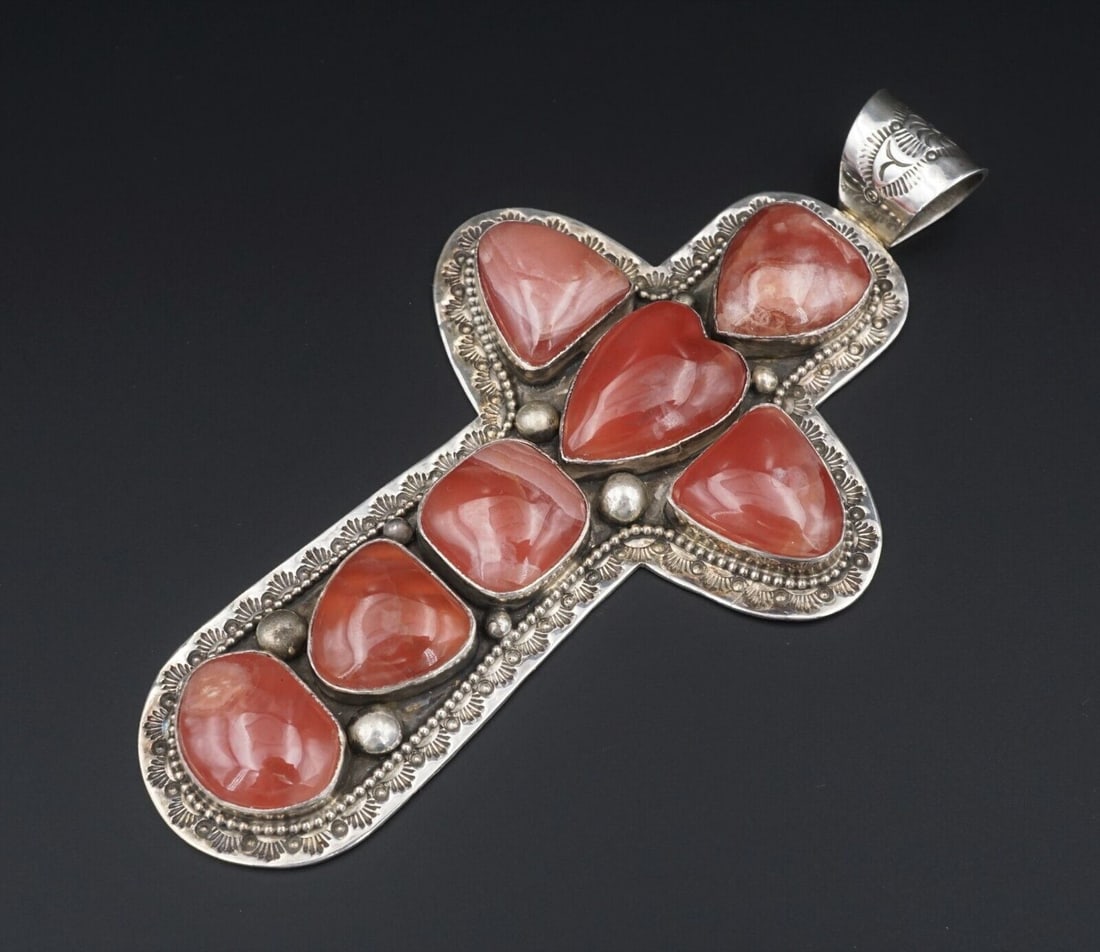 David Troutman Sterling Silver Rhodochrosite Cross Pendant 4.4" PS1966: This large carved cross pendant features natural red agate cabochons bezel set with stamped details and bead accents, creating a bold look with depth and texture. Metal Type: Sterling Silver (marked a
