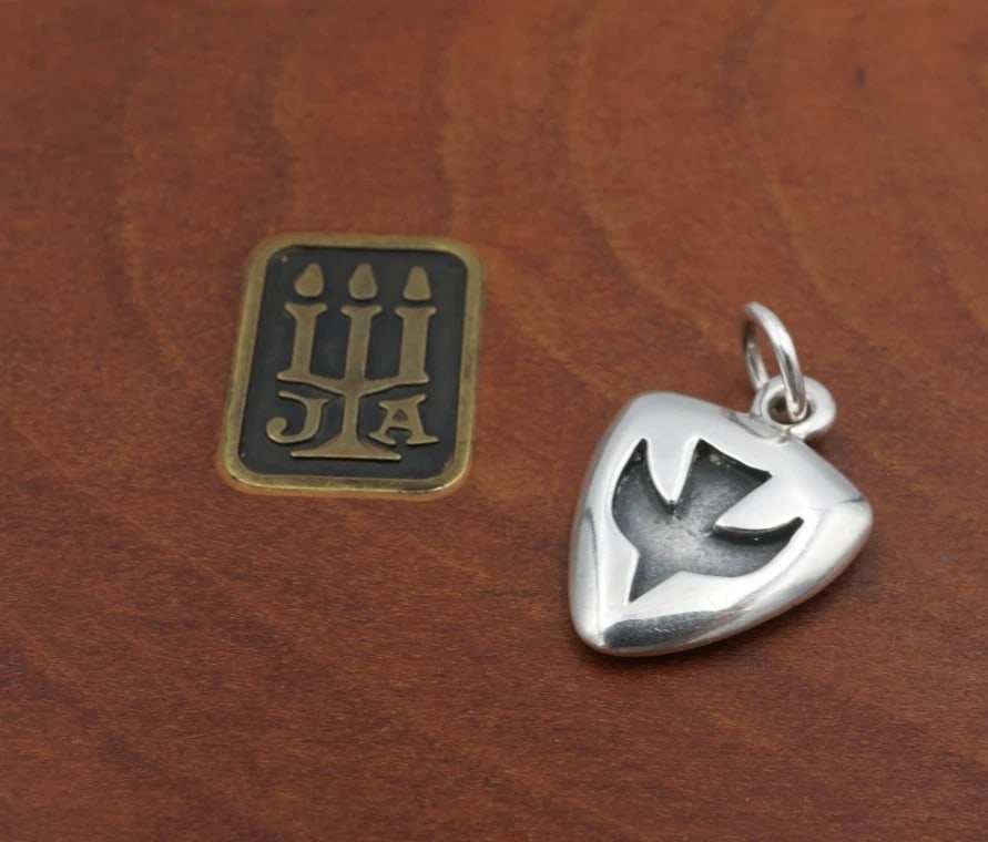 James Avery Holy Spirit Dove Shield Charm Sterling Silver 0.74" Retired CHS2318: This retired James Avery charm depicts a classic descending dove overlay in the center of a solid sterling silver shield charm. This piece would be a great gift for any James Avery collector. Metal Ty