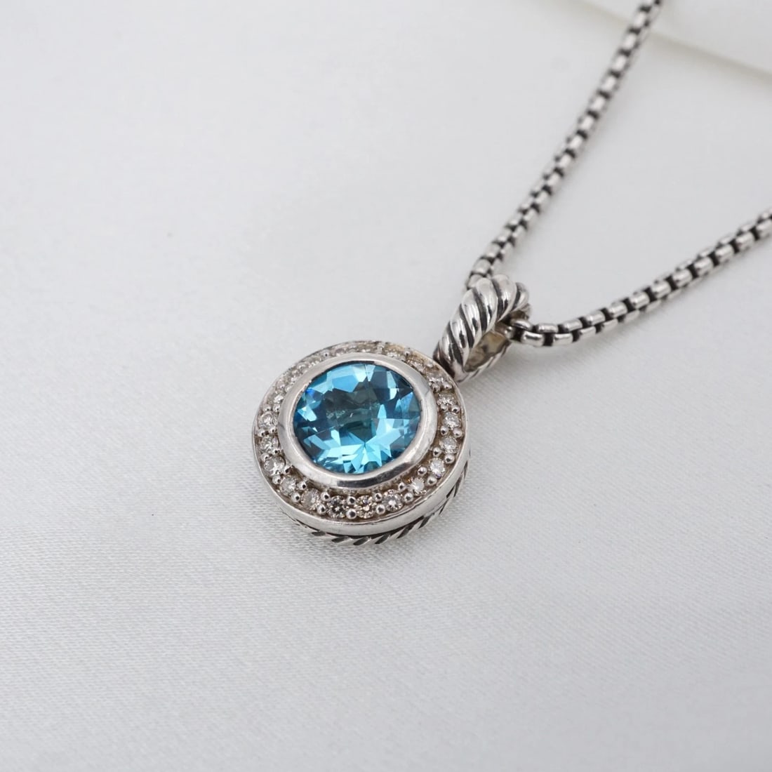 David Yurman Albion Cerise Necklace Topaz Diamond 17" Sterling Silver NS2492: This retired Petite Albion necklace from David Yurman features a round blue topaz bezel-set in a sterling silver frame embellished with a halo of natural round diamonds. Suspended on a classic Yurman 