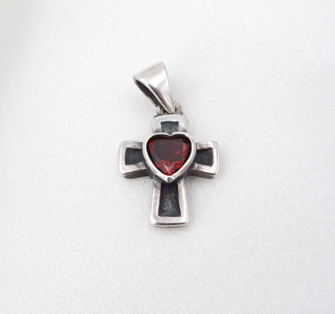 James Avery Heart Garnet Cross Pendant Sterling Silver 0.9" Retired PS2405: This James Avery pendant features a sterling silver cross with a natural heart-cut garnet set in the center. This pendant is an addition to any James Avery collection. Metal Type: Sterling Silver Nota