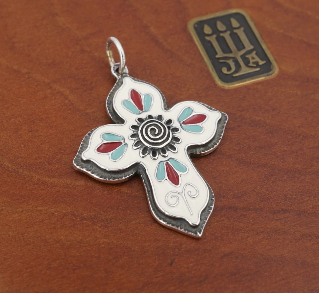 James Avery Enamel Cruz De La Flor Cross Sterling Silver 1.3" Retired PS2389: This retired James Avery design features a classic sterling silver cross pendant with an intricate spiral/flower overlay motif at center. The cross is embellished with a white enamel background decora