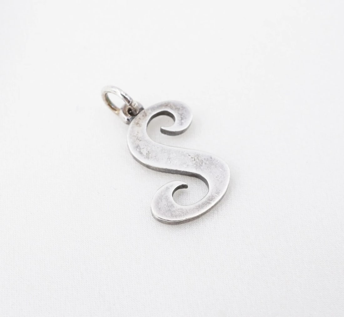 James Avery Large Script Initial 'S' Charm Sterling Silver 11/16" CHS2384: This classic James Avery charm features the letter 'S' in a large script font crafted in solid sterling silver. Metal Type: Sterling Silver Notable Marks: JA Hallmark 925 Measurements: 11/16" hang; 1.
