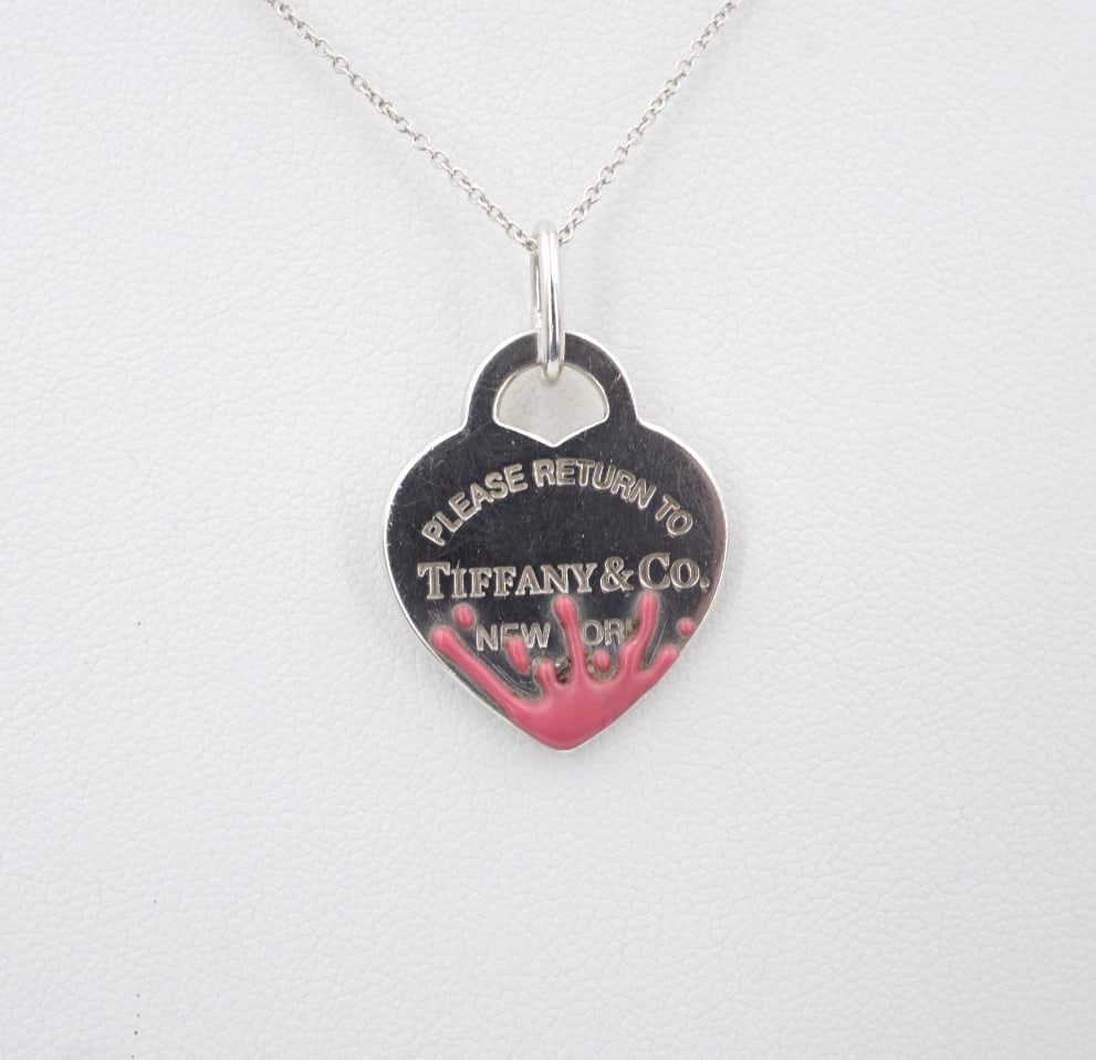 Tiffany Pink Splash Heart Tag Necklace Sterling Silver 16" 1.1mm Retired NS2289: This retired Tiffany & Co. necklace features the iconic heart tag etched with the phrase "Please Return to Tiffany & Co." crafted of solid sterling silver with a pink enamel splash design at the base.