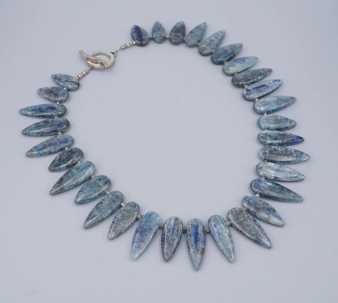 Wide Kyanite Stone Necklace Sterling Silver Bead Collar 20" Signed SJK NS2319: This bold handcrafted necklace features natural blue kyanite gemstones, each cut into elongated teardrop shapes with silvery-blue sheen and natural inclusions unique to kyanite. The stones are arrange