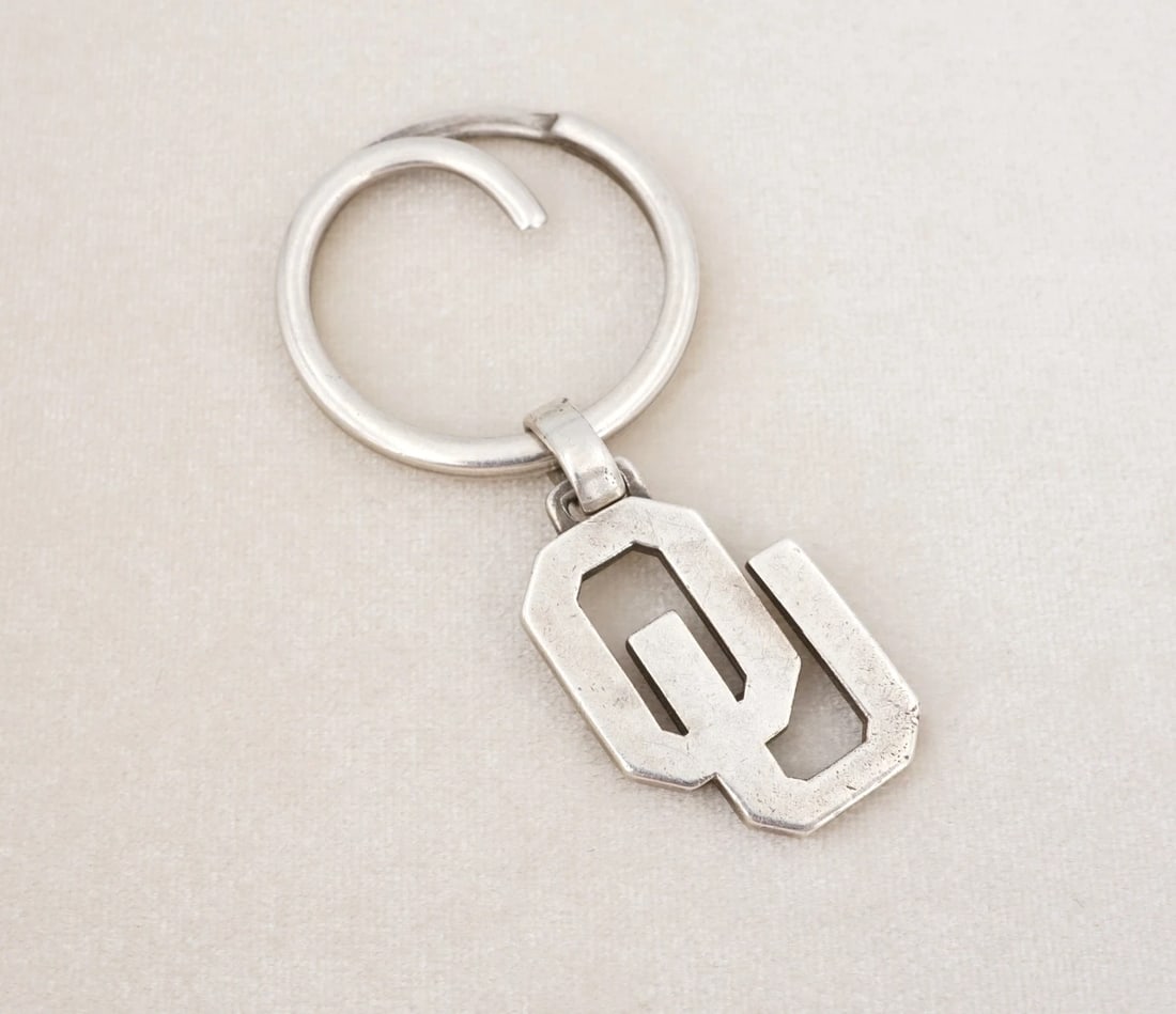 James Avery OU Pendant Keychain Sterling Silver Oklahoma 2.7" Retired M2119: This classic key ring from James Avery features an Oklahoma University "OU" symbol pendant suspended from a large key ring, all crafted in solid sterling silver. Metal Type: Sterling Silver Notable Ma