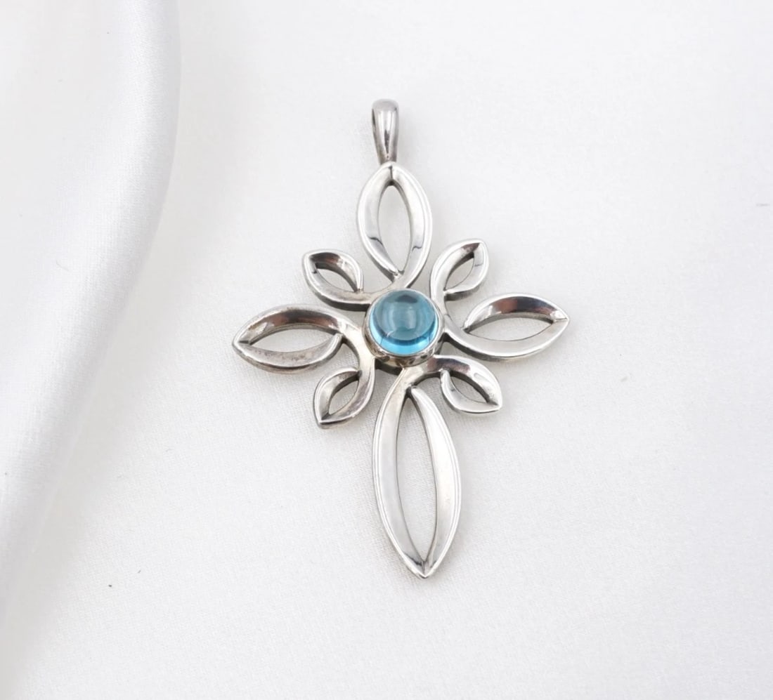 James Avery Radiant Loops Topaz Cross Pendant Sterling Silver 2" Retired PS2437: This retired James Avery "Radiant Loops" pendant features a large, openwork cross pendant with intricate, looped petal designs on each arm and a blue topaz cabochon bezel set at center. Metal Type: St