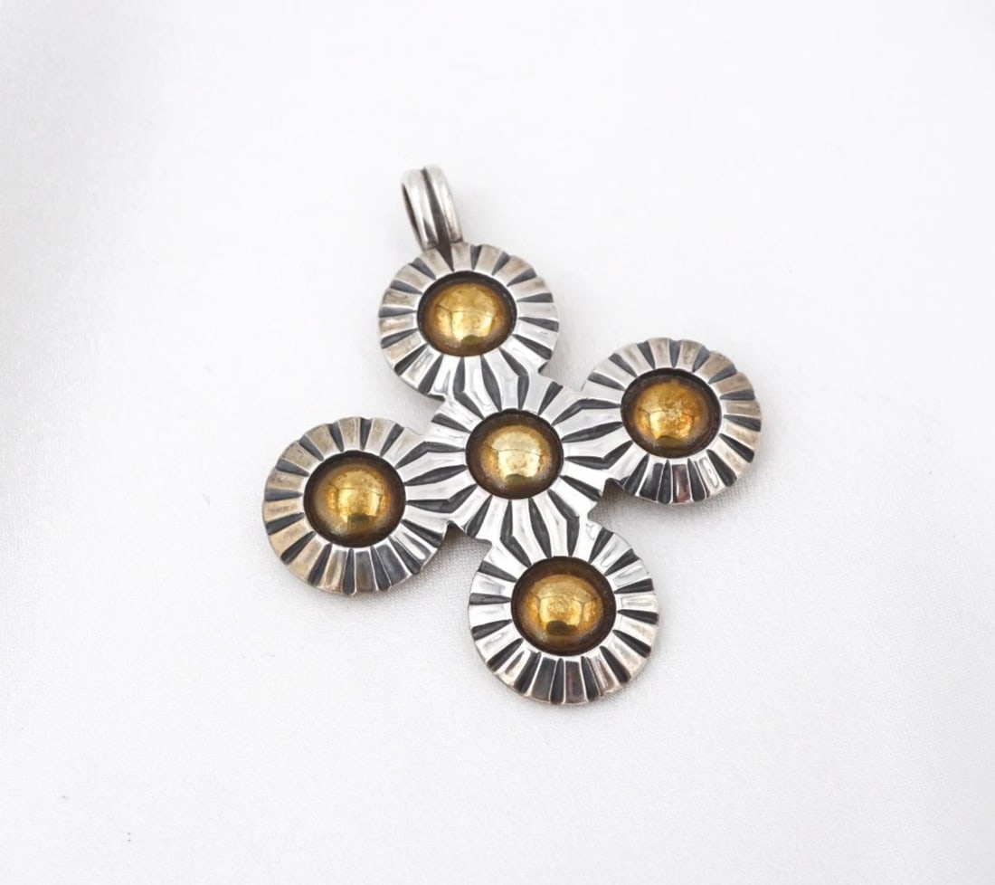 James Avery Sunburst Cross Pendant Sterling Silver Brass 1.8" Retired PS2441: This retired James Avery design features a classic sterling silver cross pendant crafted of continuous sunburst motifs with a brass dome in the center. Metal Type: Sterling Silver & Brass Notable Mark