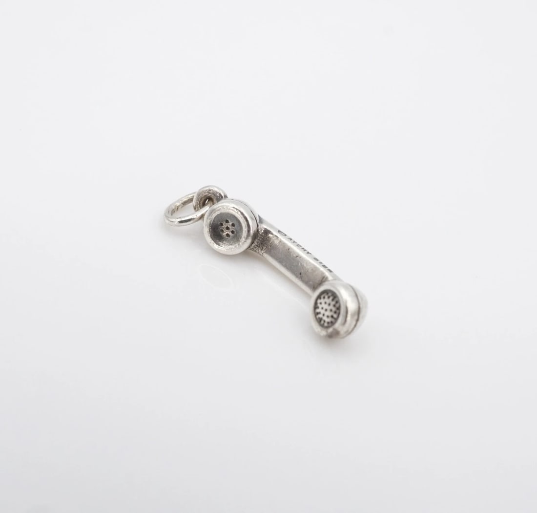 James Avery Phone Receiver Charm Pendant 3D Sterling Silver 0.7" Retired CHS2308: This retired James Avery piece features a detailed, 3D phone receiver charm crafted of solid sterling silver. Metal Type: Sterling Silver Notable Marks: Avery STER Measurements: 0.73" x 0.17"; 1.4 gra
